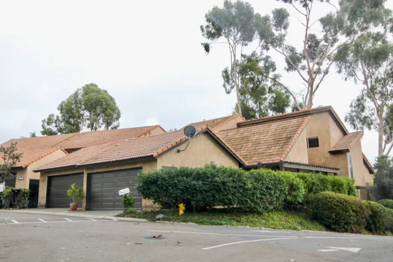 A couple of brown garages sit up against a condominium inside Buena Woods in Carlsbad CA