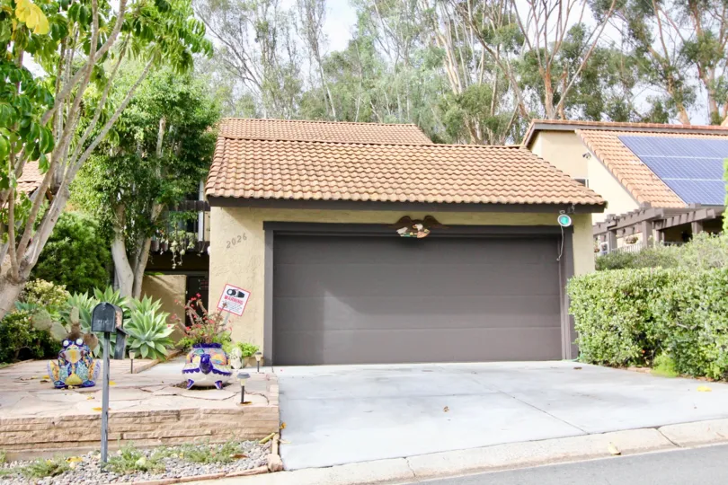 View of the driveway and garage of a Beana Woods located home