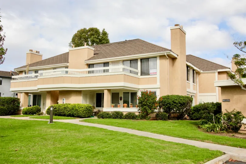 THIS PICTURE SHOWS THAT THE BUILDING IN THE CARLSBAD CREST WITH THE LAWN, PLANTS, TREES