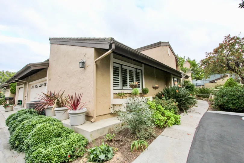 THE ESTATE IN THE CARLSBAD PALISADES WITH THE FLOWER POT, PLANTS, TREES, ROAD