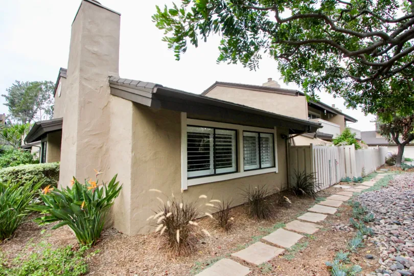 THE HOUSE IN THE CARLSBAD PALISADES WITH THE PLANTS, TREES, STONES
