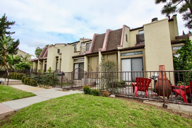 A block of condos with bright red lawn chairs & a fire place in Colina De La Costa at Carlsbad CA
