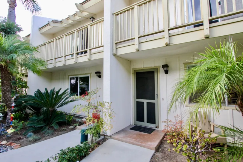 The entrance to an EL Oasis unit, with plants and patio decor lining the path.