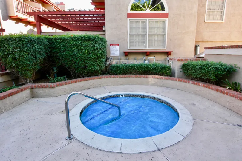 A crystal blue hot tub with metal railing inside Fairways South in Carlsbad CA