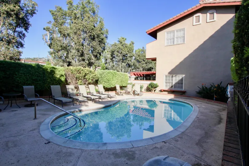 community pool with chairs next to a home in Carlsbad California