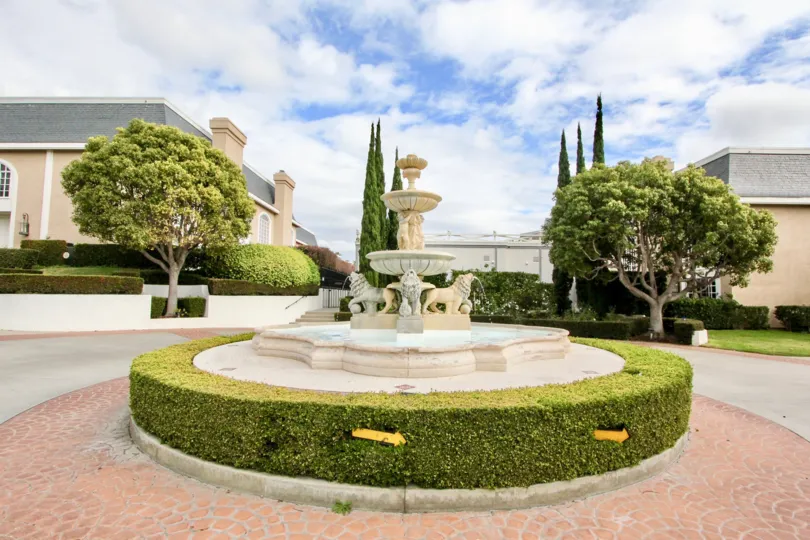 Breathtaking fountain carved stone centerpiece with perimeter hedges and a brick inlay road at the Jockey Club