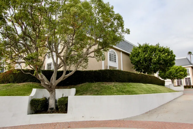 THE BUILDING IN THE JOCKEY CLUB WITH THE GRASS LAND, TREES, BUSHES, PATHWAY