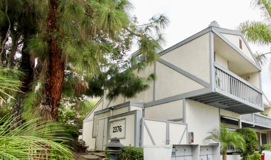 Yellow house with grey outlining and a cloudy day in Carlsbad, California