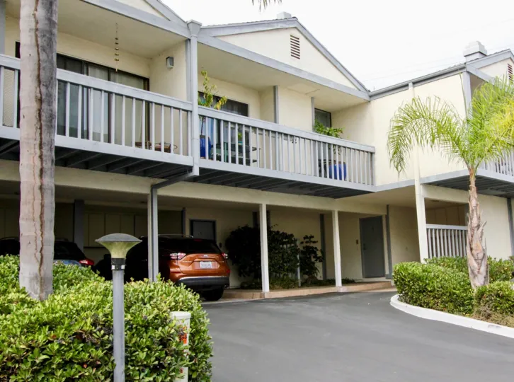 THE BUILDING IN THE LA COSTA GOLF VIEW TERRACE WITH THE CAR PARKING, BALCONI, PLANTS, TREES
