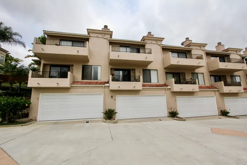 Road in La Costa Hills has four villa with flower pots and bushes