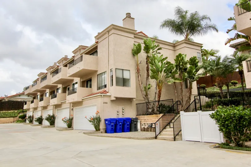 THE 2986 BUILDING IN THE LA COSTA HILLS WITH THE BANANA TREES, UPSTAIRS, PLANTS, BALCONIS, DUSTBINS