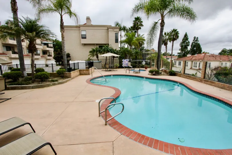 THE HOUSE IN THE LA COSTA HILLS WITH THE SWIMMING POOL, TABLES, TREES, PLANTS