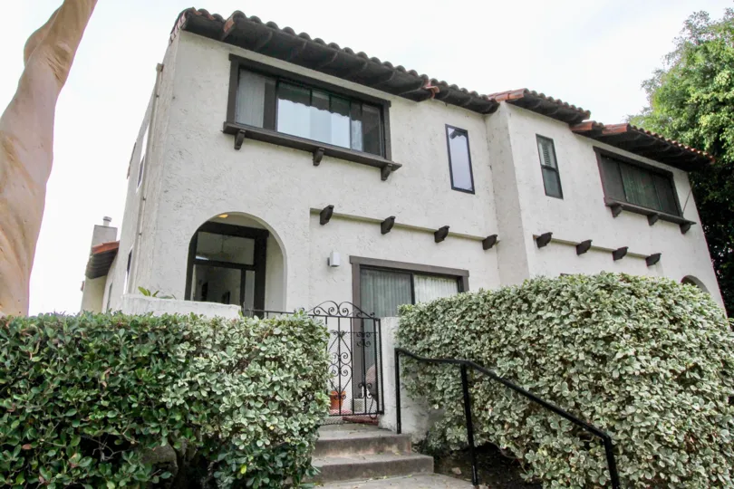 A cloudy day in the La Costa Pacific Villas with a house and plants.