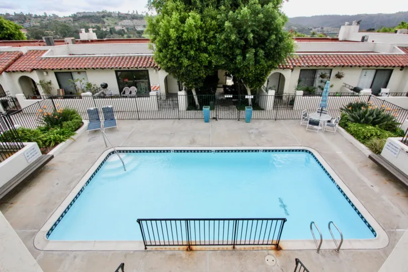 Top view of blue pool, chair & trees in La Costa Pacific Villas, Carlsbad, CA