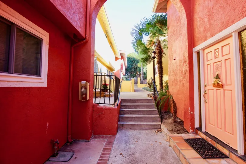 THE BUILDING IN THE LA COSTA SOUTH WITH THE WOODEN DOOR, FLOWER POT, TREES