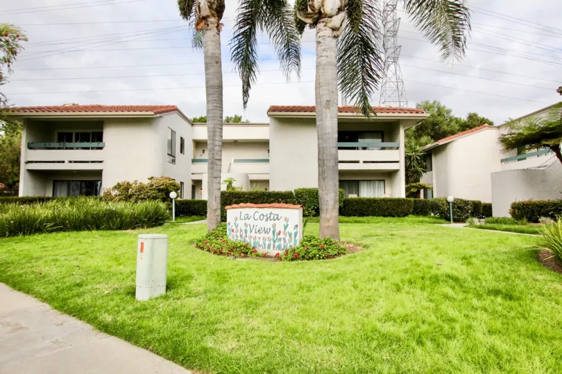 A cloudy day in the La Costa View with a beautiful garden in front of a building.