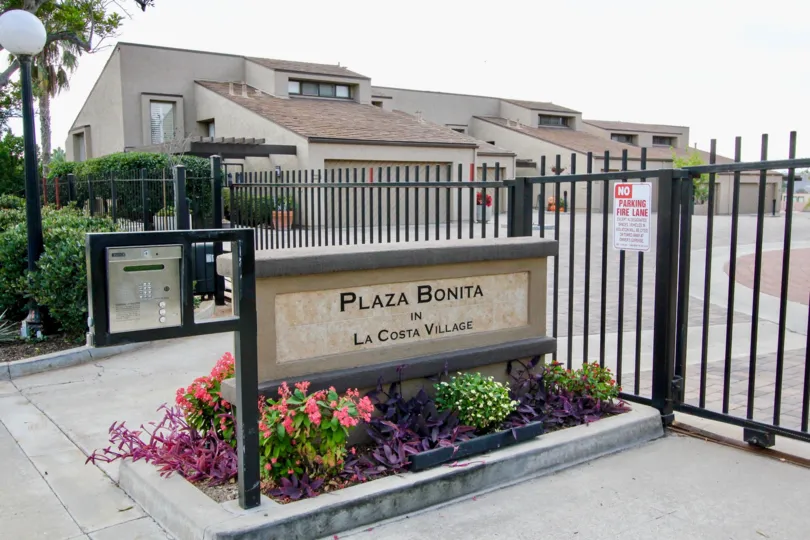 THE APARTMENT IN THE LA COSTA VILLAGE WITH THE NO PARKING BOARD, PLAZA BONITA BOARD, METER BOX, PLANTS, TREES