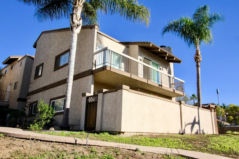 A sunny day in the Lado de Loma with a building and trees.