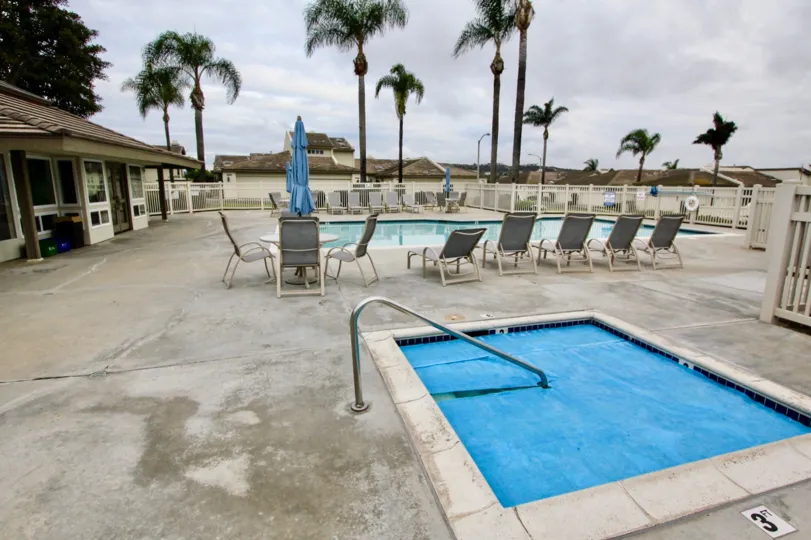 THE HOME IN THE LAGUNA DEL MAR WITH THE SWIMMING POOL, TREES, TABLES