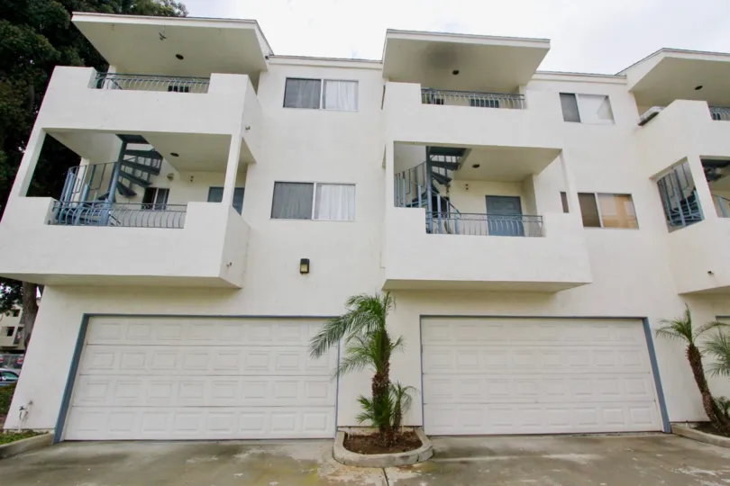 Back side of the wight color building in the Leisure View Villas with some plants and tree.