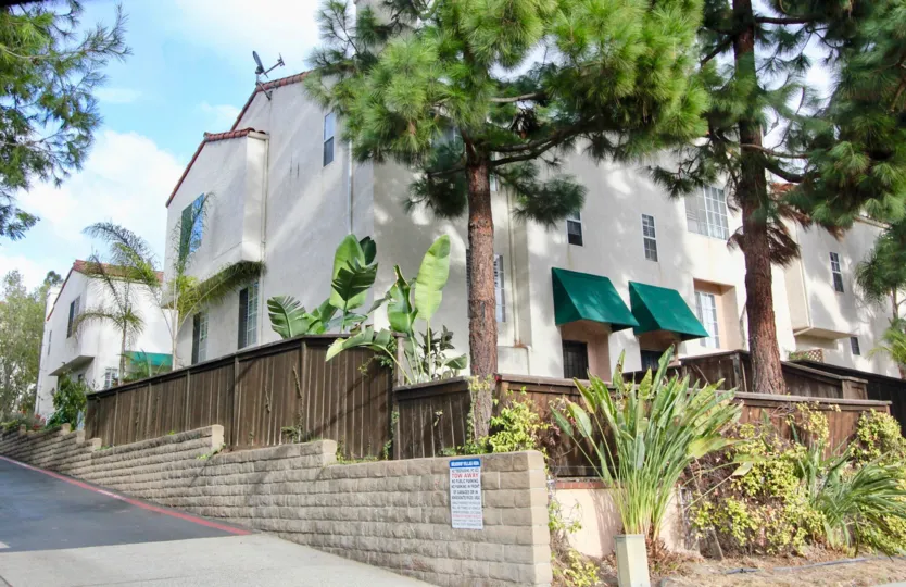 A sunny day in the Meadow Villas with residential building and trees.