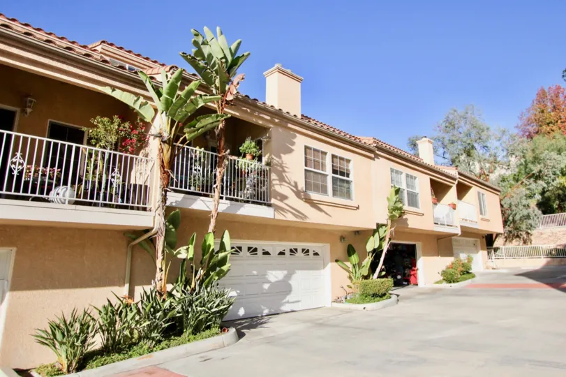 THE BUILDING IN THE MEADOWVIEW TOWNHOMES WITH THE SHUTTERS, PLANTS, TREES