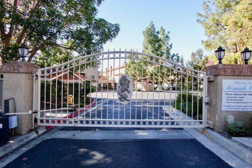 Sunny sky and a fence with a tree in the Monarch Villas Community in Carlsbad, CA.