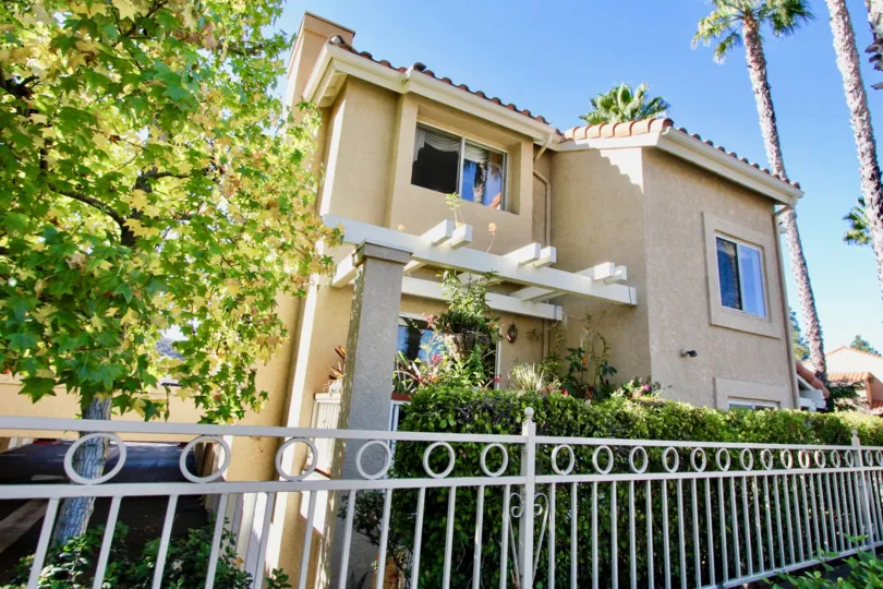 A bright day in the Monarch Villas with a nice house and trees.