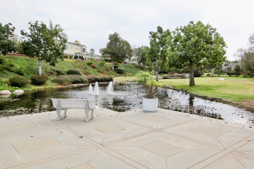 THE HOUSE IN THE SEA CLIFF WITH THE WATER LAKE, STONE BENCH, FLOWER PLANTS, TREES