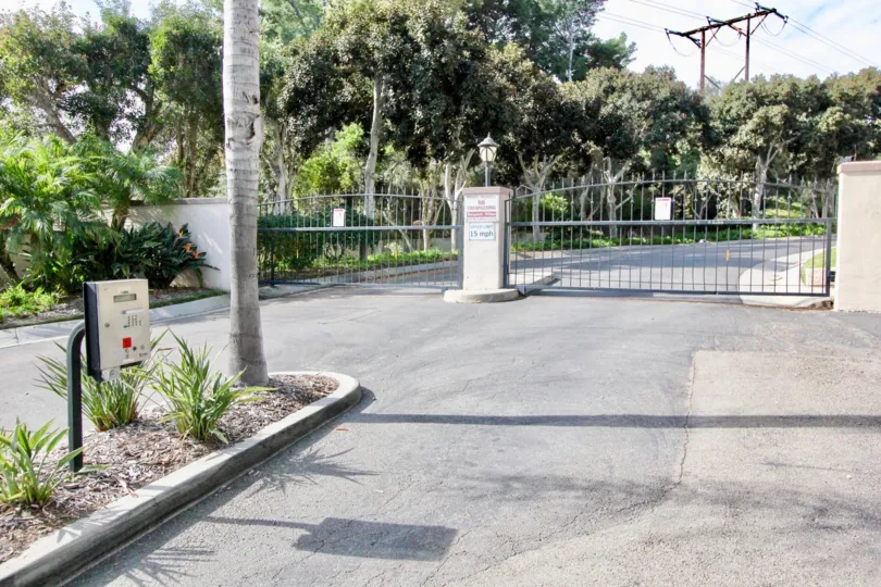 A sunny day in the Seaport Villas with a gate and trees.