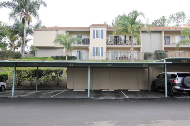 A line of covered parking spaces below The Grove homes in Carlsbad CA