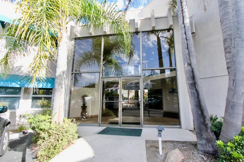 Apartment in Tres Verde made of Glass door and car is parking with trees