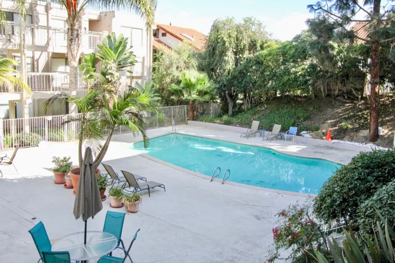 A sweet swimming pool near the apartment in the Tres Verde with some trees and plants.
