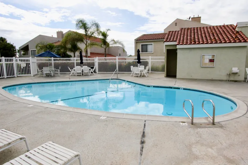 Swimming pool with tables and chairs, some umbrella's are open and some are closed in West Bluff Hills