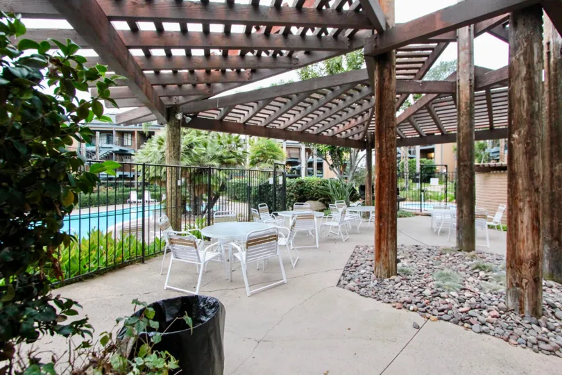 A bamboo covering over lawn chairs & tables inside Windsong Cove in Carlsbad CA
