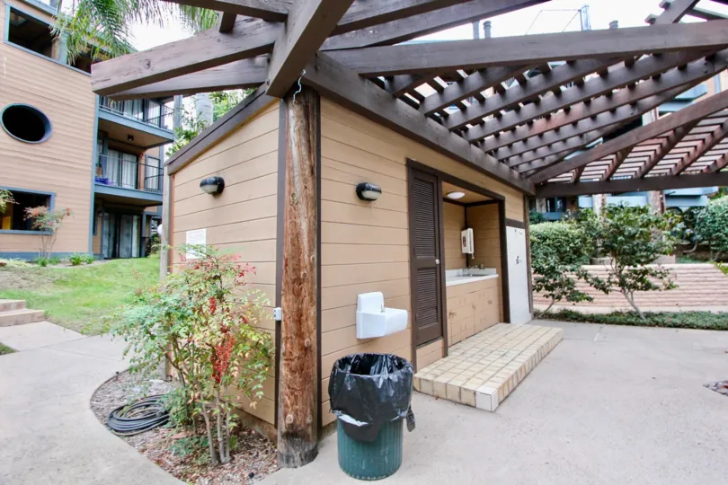 A day in the Windsong Cove with wooden roof and waste bin.