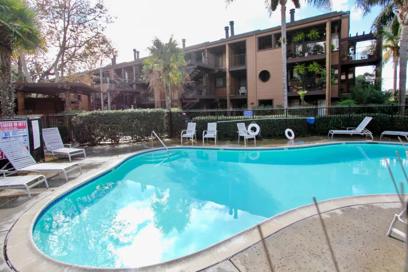 Inside the Apartment in Windsong Palms has swimming pool and chairs with sign board attached in gate