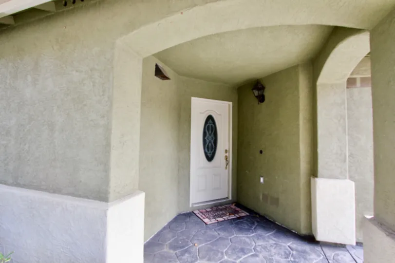 A white door with a glass oval center located in Chula Vista CA at Ada Terrace