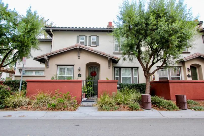 A small red wall surrounds the patios of the homes at the Agave community in Chula Vista, California.
