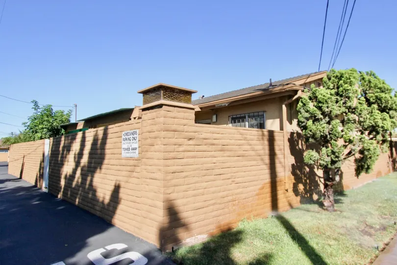 High brick privacy fence and backlane with side yards in Chula Vista