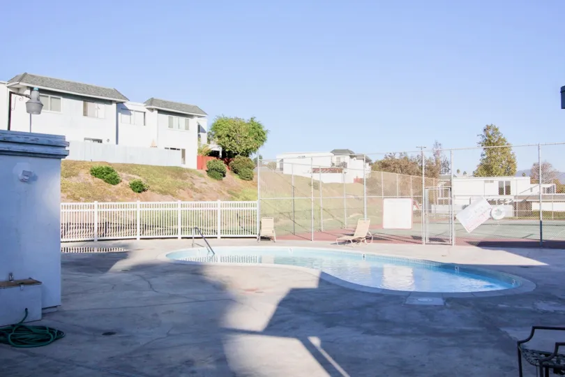A building on the hill over looks the pool and tennis courts at Autumn HIlls