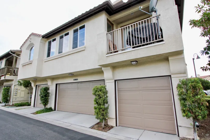 Black trim surrounds a tan garage door at Belleza condos