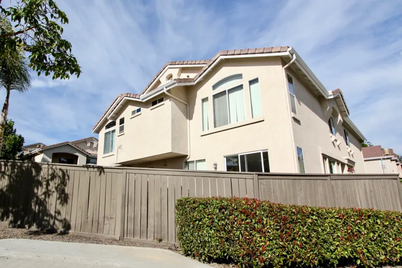 Two story light brown home behind a hedge and fence at Bolero in Chula Vista CA