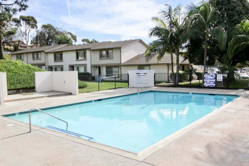Private fenced-in swimming pool surrounded by greenspace and trees for residents of Bon Vivant