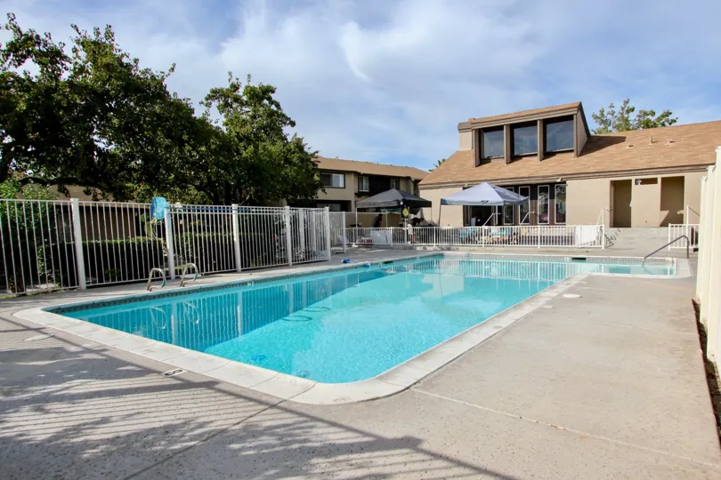 Private fenced-in swimming pool with adjacent bath house and community resident building at Bonita Terrace
