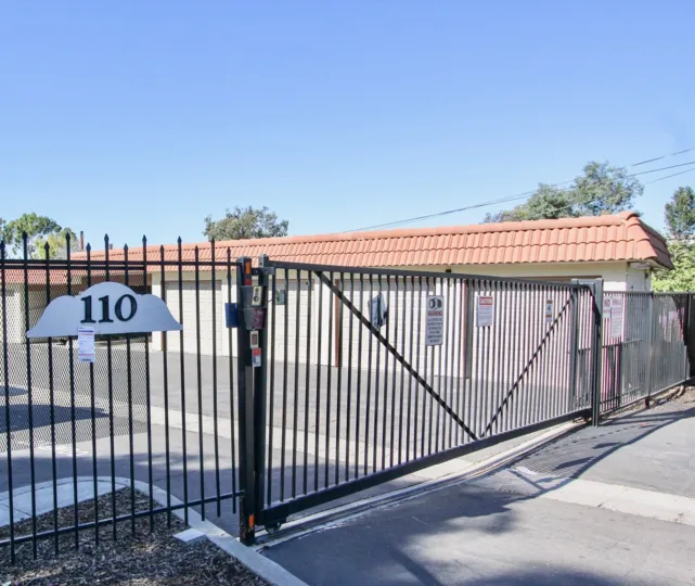 THE 110 BUILDING IN THE BRENTWOOD ARMS WITH THE STEEL GATE, ROAD SIDE, POST WIRES