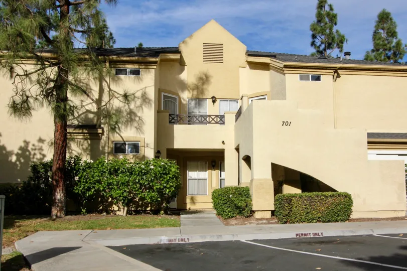 The exterior of 701 Camelot with the balcony and large trees