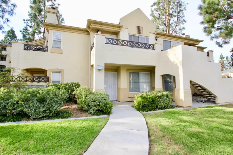 A sunny day in the area of Camelot, sidewalk, condo, grass, outside, balcony, trees, stairs