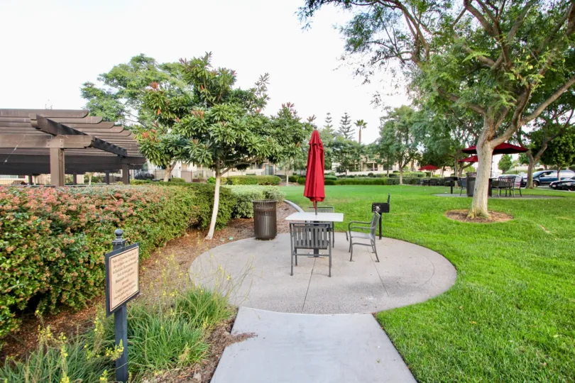 Large community greenspace with seating and pergola covered areas in Capria
