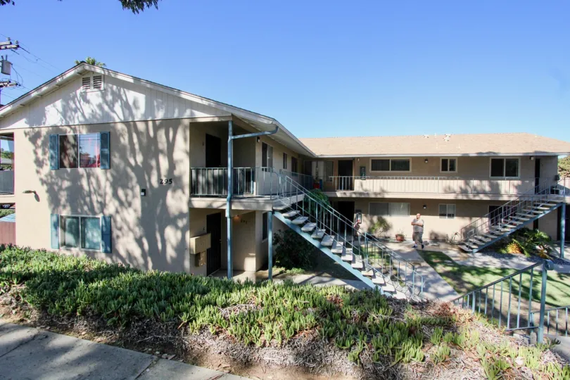 View of front of apartments with staircases leading to the upstairs apartments at Casa Verde in Chula Vista, Ca.